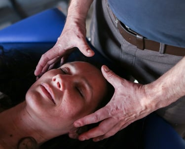 Les mains du praticien entourent la tête de la patiente