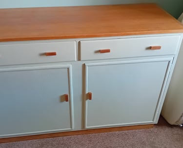 Finished cupboard painted a very light green with natural oak top and handles.