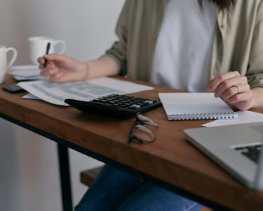 Assistante administrative : calculatrice et nombreux papiers triés et rangés, gestion des commandes