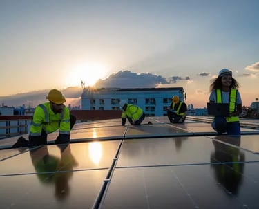 Fotografía de personas sobre el techo de una empresa portando equipo de protección instalando panele