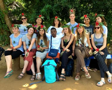 Group of tourists posing for a photo with a friendly local guide after completing the Zanzibar spice tour at a traditional 