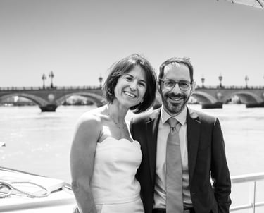des mariés sur le pont d'un bateau devant le pont de pierre de bordeaux