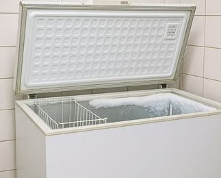 Freezer horizontal branco com tampa aberta e acúmulo de gelo, manutenção em Curitiba pela Veralice Refrigeração.