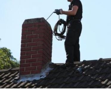 A Chimney being inspected from the roof