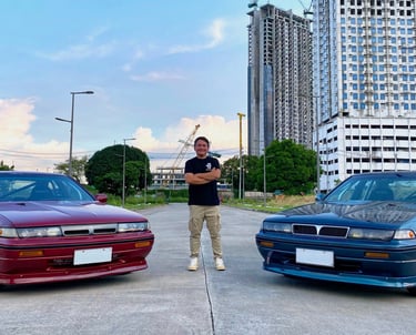a man standing in the middle of two parked drift cars