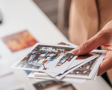 a person holding a bunch of photos doing a choice for the creation of a unique luxury print