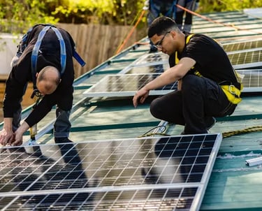 Dos hombres con camisa negra y portando equipos de protección personal trabajando en la instalación