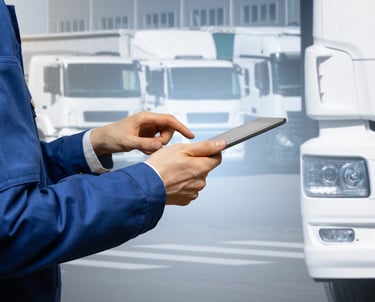 Manager with a digital tablet on the background of trucks. Fleet management