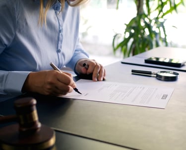 Firma de documento legal con mazo en escritorio