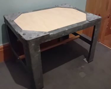 A plywood top has been added under the rivetted corners and wooden bar joining the 2 pairs of legs