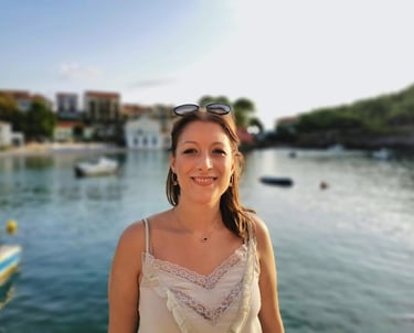 a woman in a white dress and sunglasses on a boat