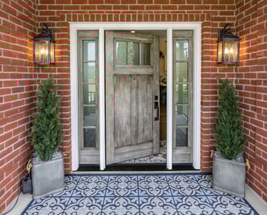 a front door with a brick wall and a potted planter