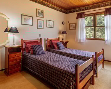 Quarto com duas camas com lençóis com estampa xadrez