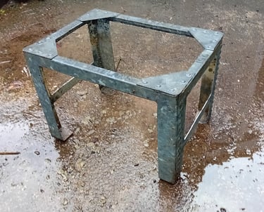 The sides and base of the tank have been cut away to leave 4 legs with cross bars and the top edges