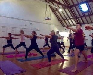 a group of people doing yoga exercises in a gym