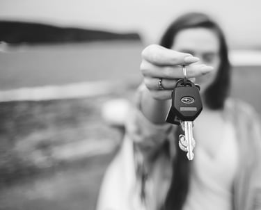 grayscale photo of a woman holding a keychain and a car keys 