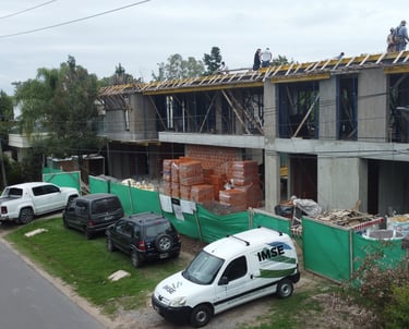 a group of people standing on a building with a truck parked in front of it