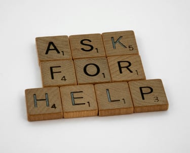 Scrabble tiles spelling ask for help on wooden surface, psychological counseling