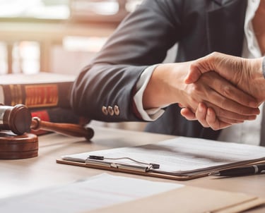 Apretón de manos en oficina legal, asesoramiento en Derecho Laboral.