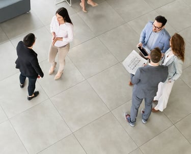 a group of business people standing in a modern open office space