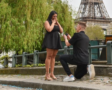 Un jeune aglais demande en fiançailles sa copine sur les bords de Seine, avec la tour Eiffel et un saule pleureur en fond
