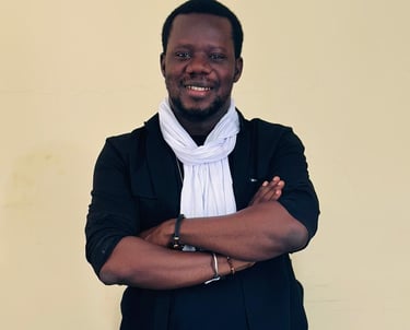 a man in a suit and scarf standing in front of a wall