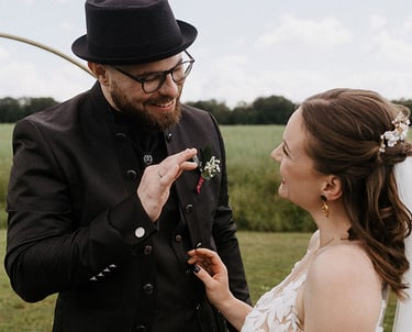 das alternative Hochzeitspaar strahlt sich nach dem Einzug an. der Bräutigam zeigt ihr, wie toll er ihren Style findet