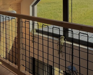 Pierwsze piętro domku (atresola) z dużym trójkątnym oknem od połowy ściany aż po dach.