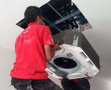 Suasana Aircond installer mounting new ceiling cassette AC unit.