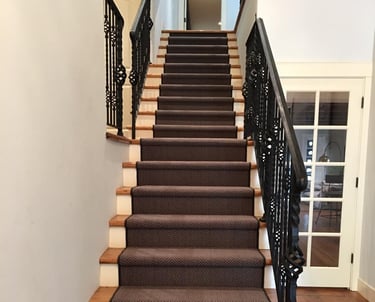 a staircase with a black and white carpet and a black stair case
