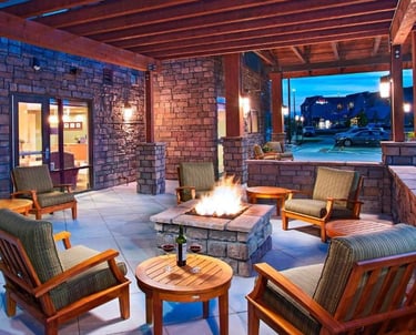 a patio with a fire pit and chairs