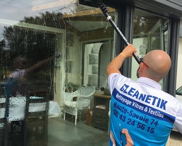 homme qui nettoie une vitre à Annecy