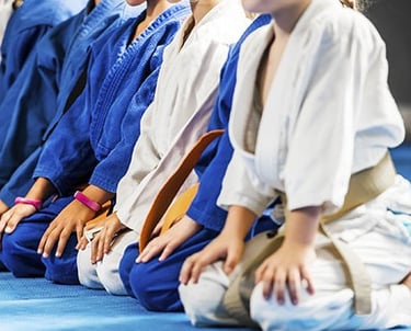 Jeunes judokas à genoux au salut