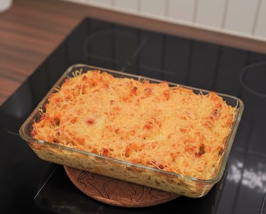 Assiette de macaronis crémeux aux lardons fumés grillés, parsemés de fromage râpé et de persil frais