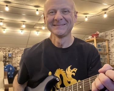 smiling man owner playing guitar
