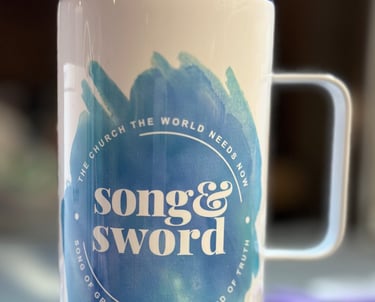 White coffee tumbler with blue splash "Song & Sword" "The Church the World Needs Now" "Song of Grace with the Sword of Truth"