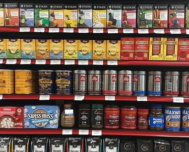 Round Hill Market shelf with coffee, tea, and juice brands like Stash, Twinings, Illy, and Ceres.