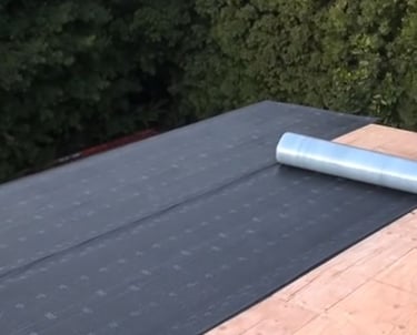 Waterproof roofing tar paper installed on Massachusetts-built shed for durable weather resistance.