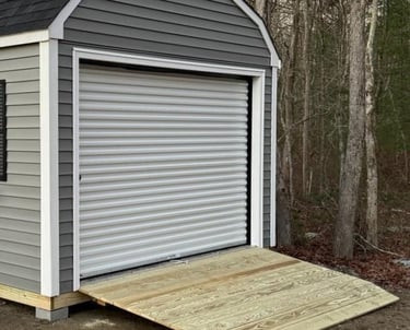 Custom shed with roll-up garage door built in Massachusetts for versatile storage solutions.