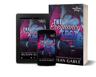 A table, a cell phone, and a paperback version of the book The Pregnancy Test by Susan Gable. 