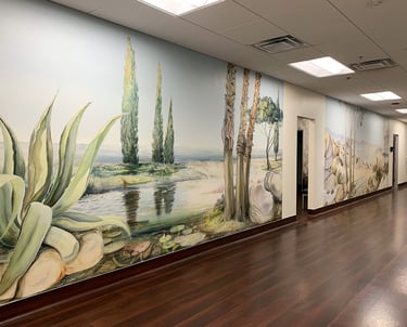 Two large panoramic murals in a clinic hallway depicting Southern Californian landscapes.