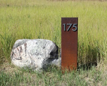 a stone and steel address marker