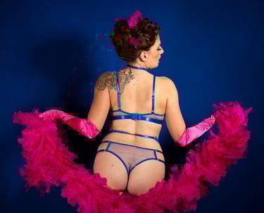 Glamour. Femme lingerie bleue, boa et gants rose.
