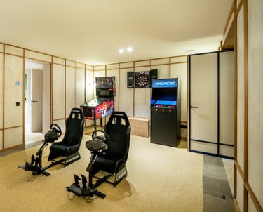 Game room at Villa La Gratitud with PlayStation simulators, pinball, arcade, and darts.