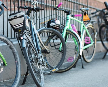 A bunch of bikes leaning up against a fence