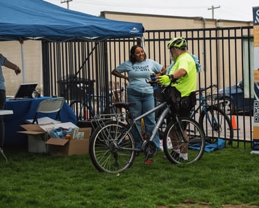 Man with his bike, speaking to a Local Motion staff member at their booth