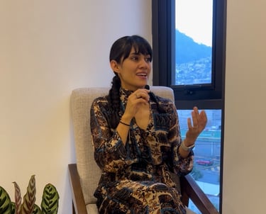 a woman sitting in a chair with a plant in front of a window