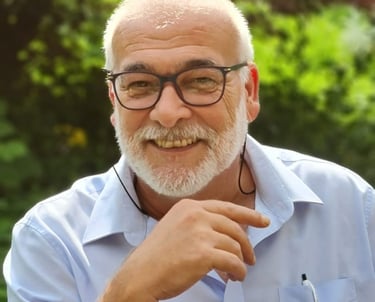 Patrick Beiner with a beard and glasses sitting in a chair