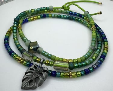 Tiny iridescent glass beads in vibrant shades of green blue & gold in a triple wrap bracelet design