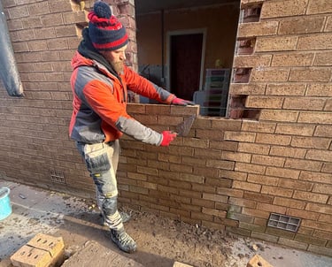 Bricklayer repairing brickwork on residential property in Southport